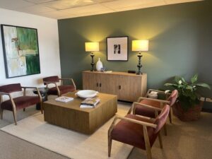 Denver therapy office waiting room with brown velvet chairs and two lamps in front of a green wall