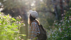 A girl walks through a natural forest.